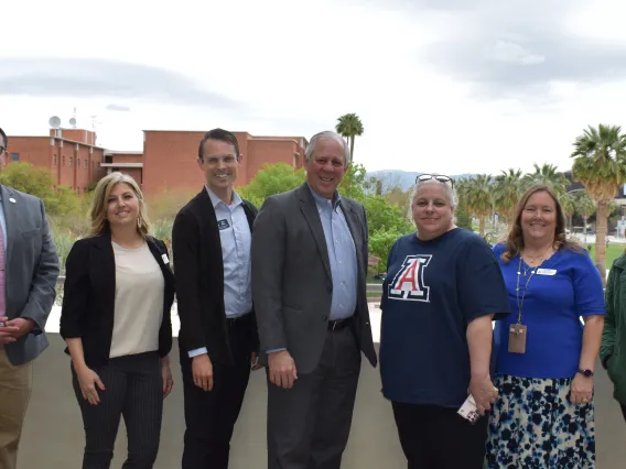 UA Cares Ambassadors who helped recruit blood donors and save 241 lives pose for a photo with President Robbins in front of the UA Mall.