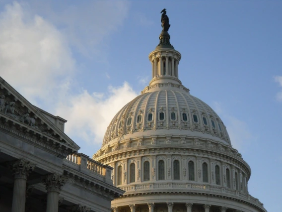 A photo fo the U.S. capitol dome with a blue sky seen behind it