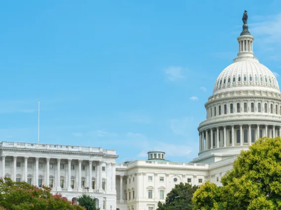 Wide shot of the United States Capitol in front of a blue sky