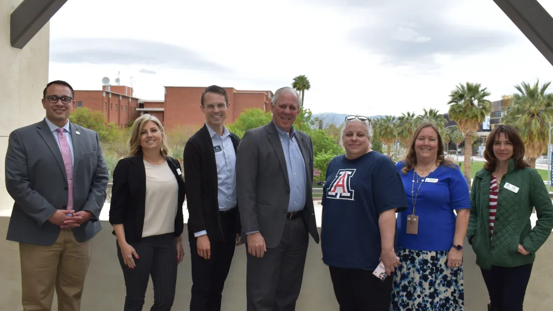 UA Cares Ambassadors who helped recruit blood donors and save 241 lives pose for a photo with President Robbins in front of the UA Mall.