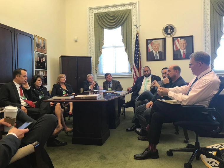 Arizona lawmakers sit together in a congressional leader's office for a meeting