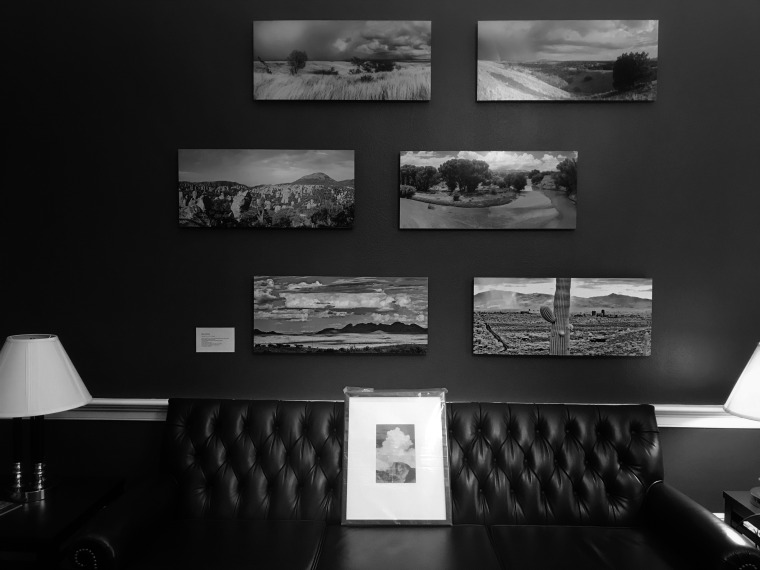 A collection of photos mounted onto a wall in a congressional office can be seen