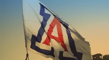 A University of Arizona flag is seen waving as dusk falls over Tucson