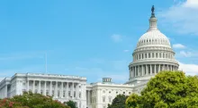 Wide shot of the United States Capitol in front of a blue sky